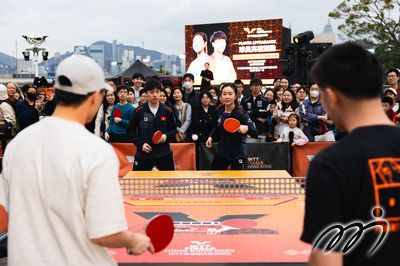 Hong Kong, China's NG Wing Lam and Baldwin CHAN engage joyfully with fans at the WTT Finals Park.